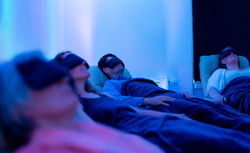 People wearing eye masks in recliner chairs during guided meditation at Soul Spa